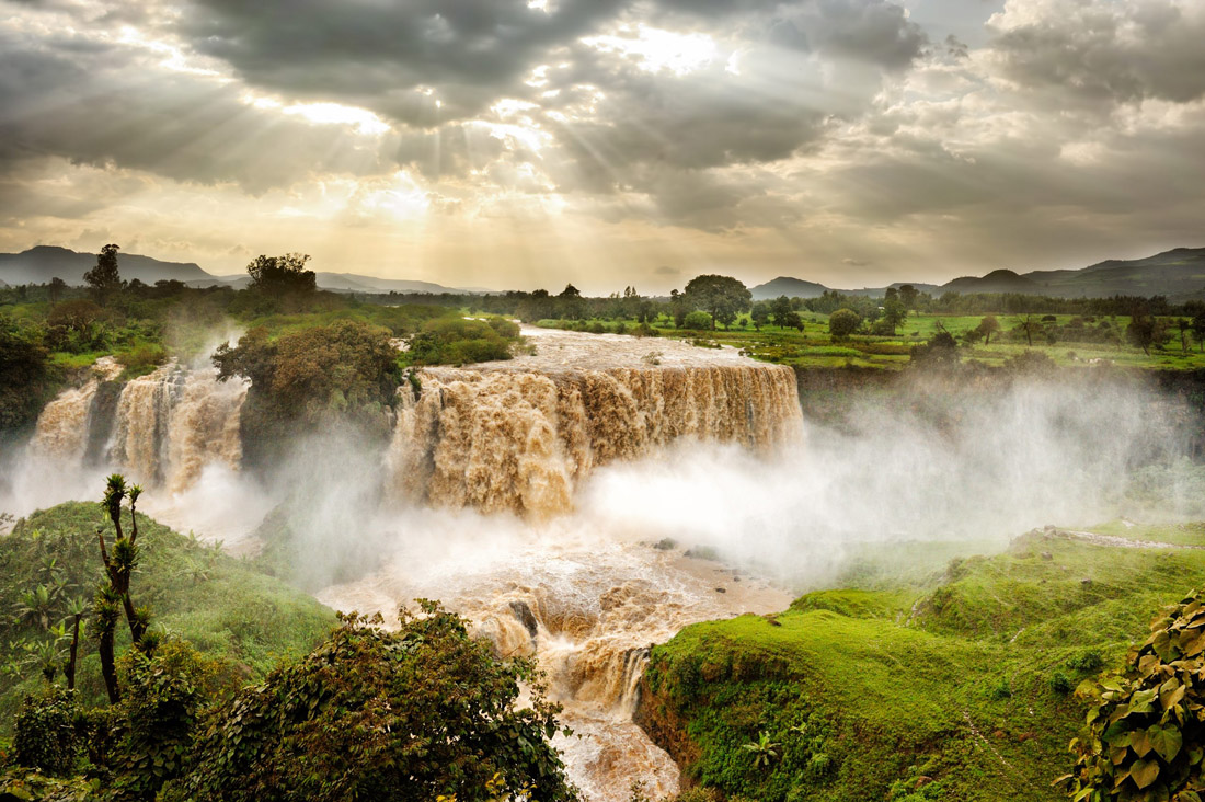 Topic is Travel Destination to Ethiopia. Luscious greens among the Blue Nile Falls, in Issat, Ethiopia, Africa.