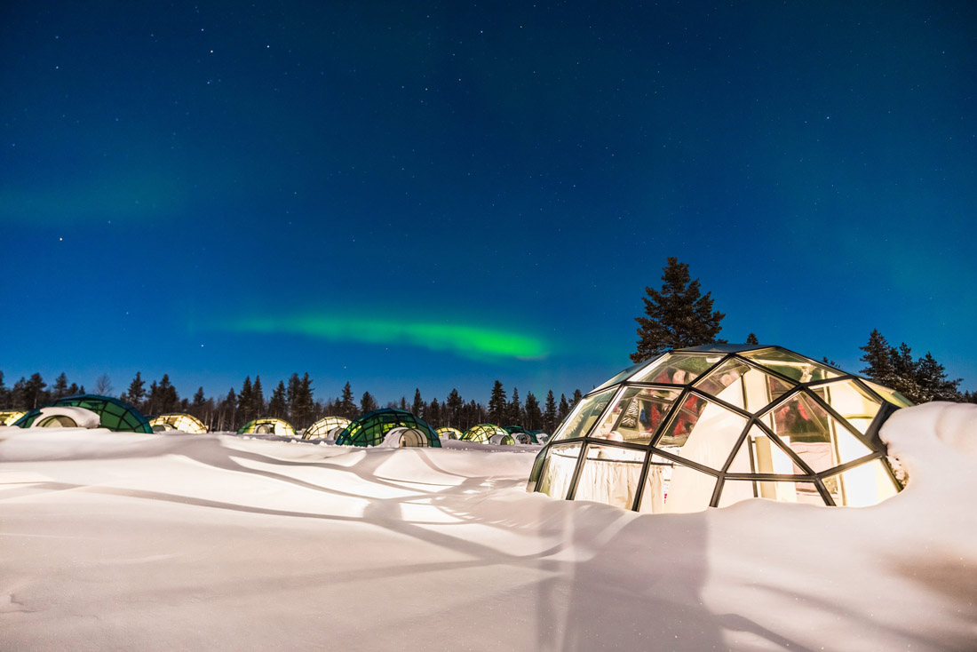 Topic is Travel Destination to Finland. Striking Northern Light in Finland over igloo house.