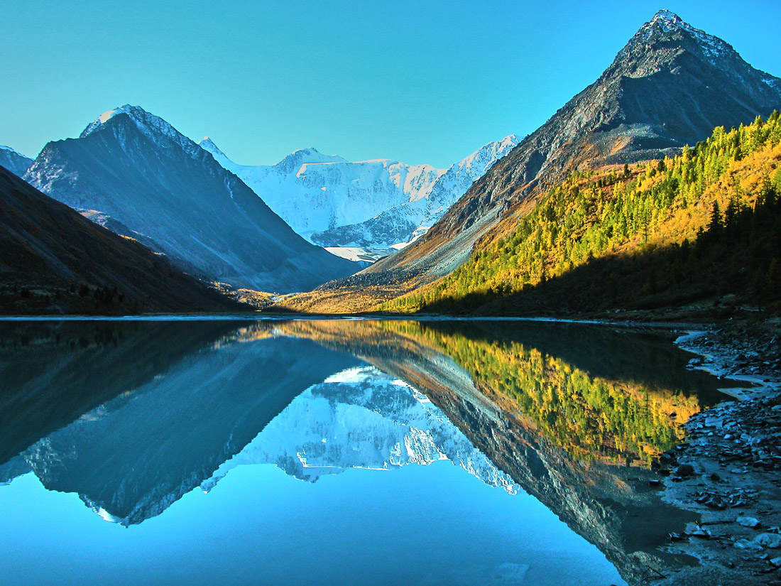 Topic is Travel Destination to Kazahstan. Reflection of mountains in the Belukha Mountains and Lake Akkem in Kazahstan.