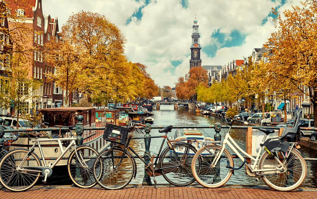 Topic is Travel Destination to Netherlands. These bicycles are over the Amsterdam City canal, Netherlands, which makes for a picturesque scenery.