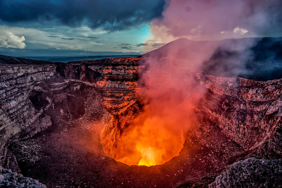 Topic is Travel Destination to Nicaragua. Volcano crater eruption with flowing lava and smoke, at the Masaya, Nicaragua.
