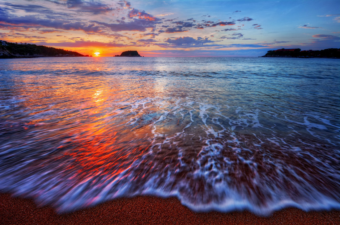 Topic is Travel Destination to Saint Kitts and Nevis. Ocean sunrise with bright clouds and dynamic breaking waves.