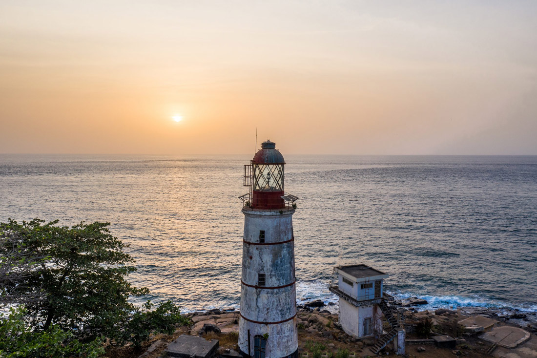 Topic is Travel Destination to Sierra Leone. Against a gorgeous sunset, Old lighthouse in Freetown, Sierra Leone.
