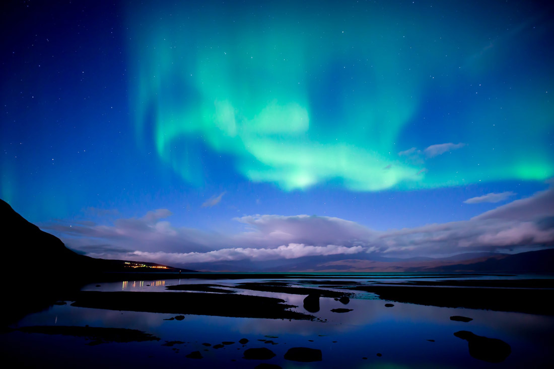 Topic is Travel Destination to Sweden. Northern lights dancing over calm lake in Abisko National Park.