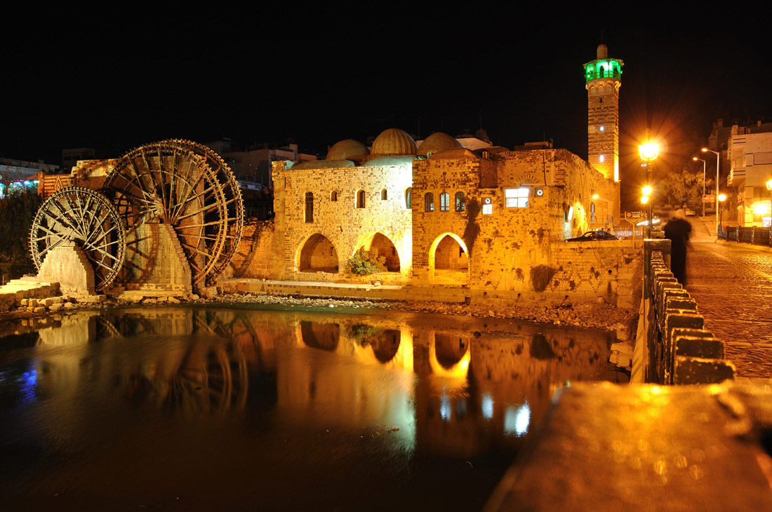 Topic is Travel Destination to Syria. Norias in Hama during the night.