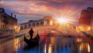 Gondola navigating Venetian waters near the iconic Rialto Bridge, Italy.