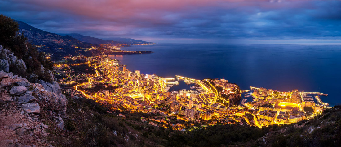 Monaco at blue hour: panoramic view of the port leading to Monte Carlo.