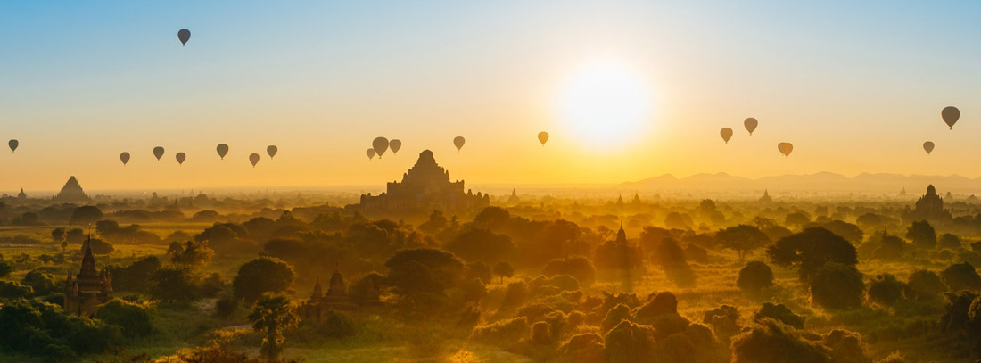 Myanmar's Bagan at sunrise, adorned with hot air balloons and ancient Buddhist temples.
