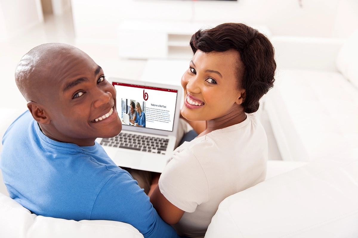 Social networking platform to interact with others. Discussion forums & vast areas of interests with simplified site structure. Welcome to BlahFace.com, a social media platform. Photo of a happy young African-American couple with laptop computer viewing BlahFace website.